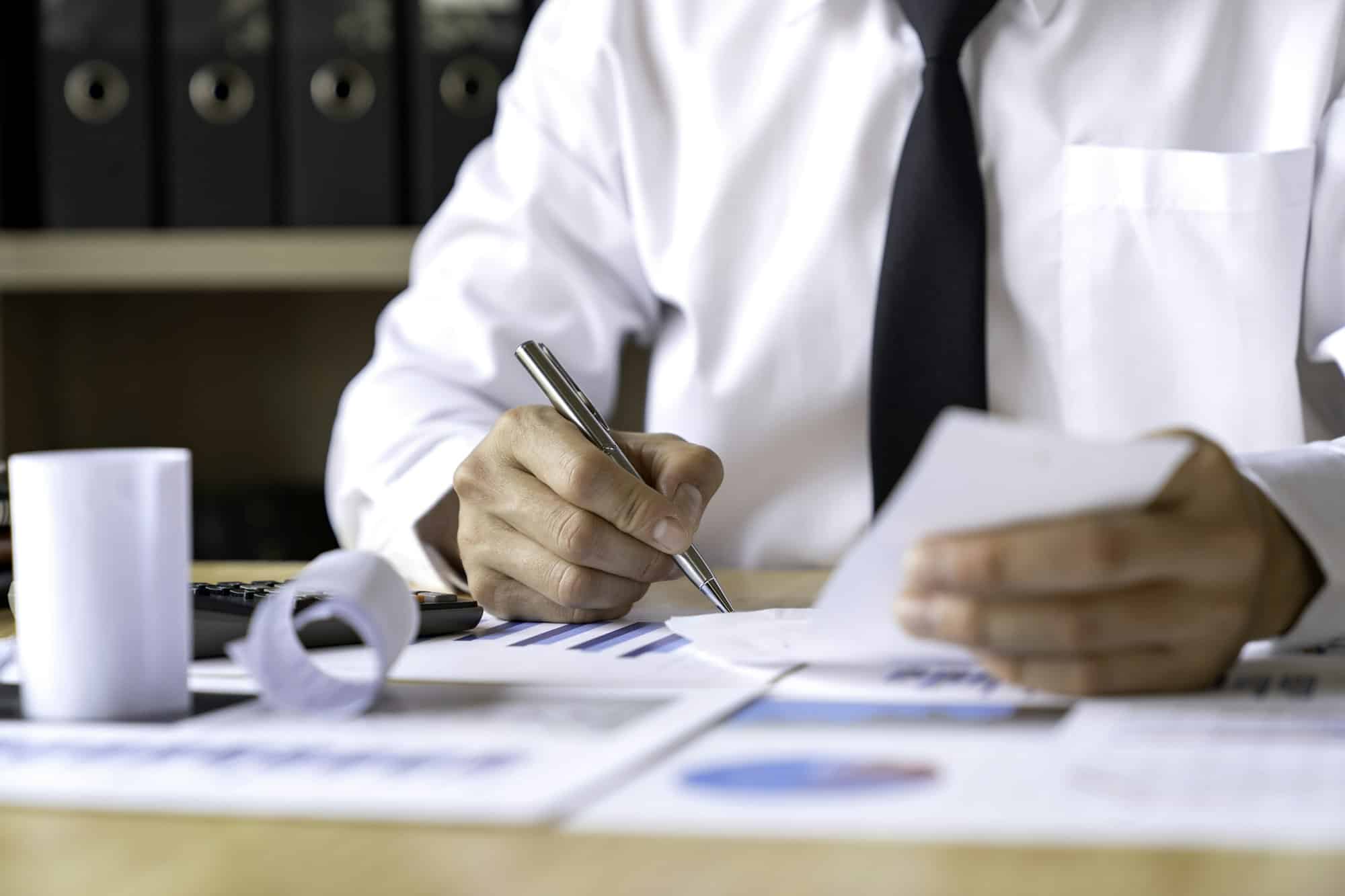 Close-up of businessman's hands collecting bills for tax refund and tax savings, finance banking and